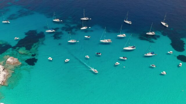 Aerial view of anchored boats on paradise turquoise sea of Vrika beach at Paxos island Greece