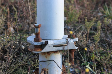 Rusty bolts and nuts on the hinge of the metal mast