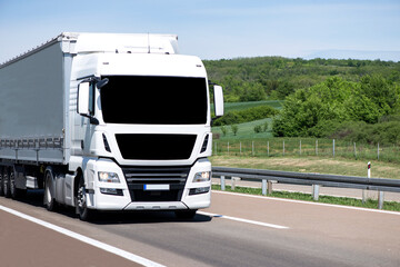 Naklejka premium White Semi-trailer driving along highway. Goods Delivery by roads. Services and Transport logistics