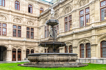 Fototapeta na wymiar Beautiful stone fountain at the facade of the Vienna Opera House