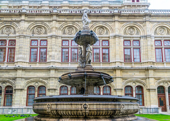 Fototapeta na wymiar Beautiful stone fountain at the facade of the Vienna Opera House