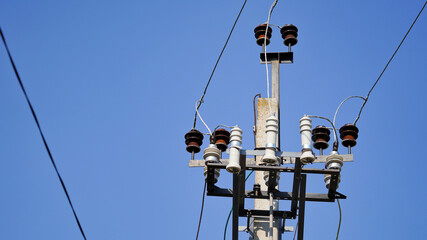Close-up high voltage power line on a background of blue sky on a sunny day. Electro pole, pole...