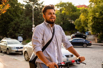 The young man have nice mood while rides an electric scooter