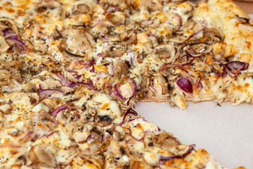 Large appetizing pizza with cutaway chicken and mushrooms