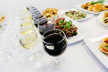 red and white wine with snacks from a famous chef on a white tablecloth on a festive table