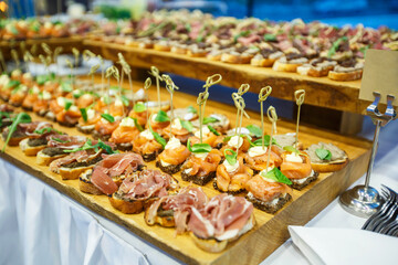 a table with meat and vegetable dishes at a corporate party with a sign for a sign
