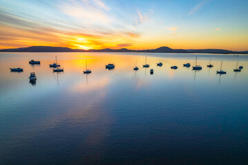 Aerial sunrise waterscape with boats and high cloud