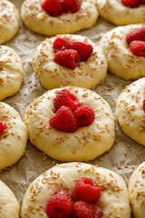 Raw raspberry sweet  buns  prepared for baking on baking paper,  close up view. Traditional yeast buns