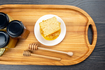 Fresh flower honey and honeycomb with spoons on a wooden background. Organic Vitamin Health Food