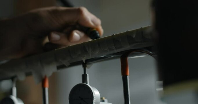 Luthier marks frets on the guitar by black marker before sanding, musical instruments repair shop, 4k 60p 10 bit