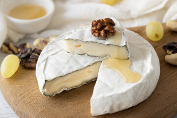 Brie cheese with nuts, honey and grapes