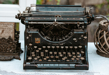 Close-up of Vintage old fashioned typewriter machine Underwood on desk next to window in light...