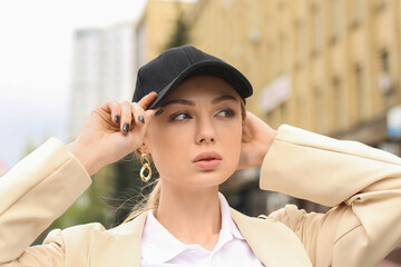 Pretty woman wearing baseball cap in city