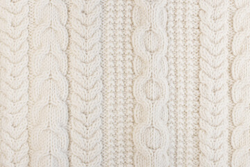 texture of a natural wool knitted sweater ivory color close-up. fabric texture for your mockup