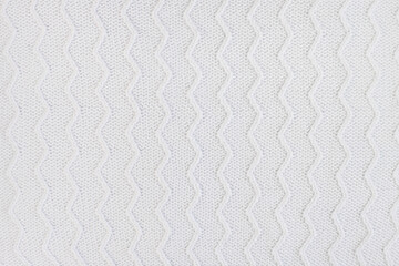 texture of white knitted fabric for a winter sweater close-up. place for your mockup