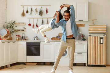 Dad spinning his son in the air while playing together and having fun at home