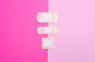 Adhesive medical plasters on pink background