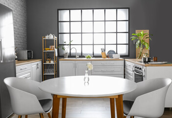 Dining table with flower in interior of modern kitchen