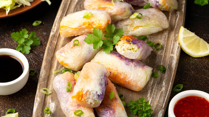 Fried Vegan spring rolls, rice paper dumplings with sweet and purple cabbage, rice noodles and carrots