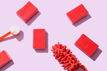 Cleaning sponges and brush on pink background