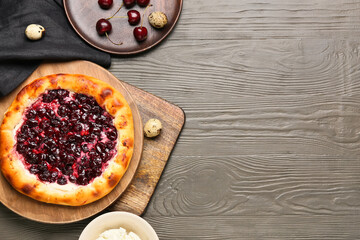 Plate with tasty cherry khachapuri, cottage cheese and quail eggs on wooden background