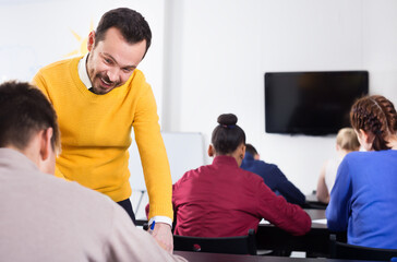 Obraz premium Teacher explaining a difficult problem to student during test in the class
