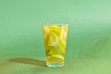 Glass of tasty lemonade on color background