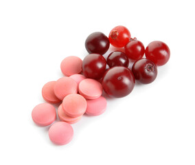 Cranberry pills and berries on white background