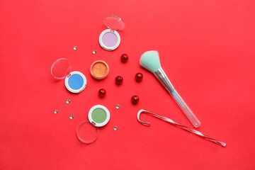 Christmas composition with makeup cosmetics on red background