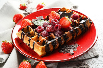 Plate of tasty Belgian Waffle with berries on table