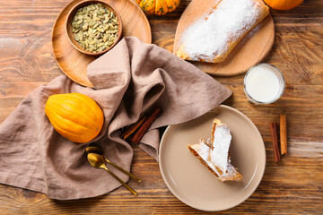 Composition with tasty pumpkin strudel and glass of milk on wooden background
