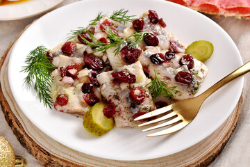 Sliced herrings with cranberry on white plate