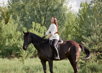 Beautiful long-haired girl riding a horse