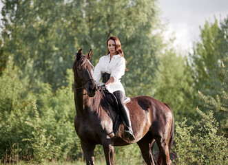 Beautiful long-haired girl riding a horse