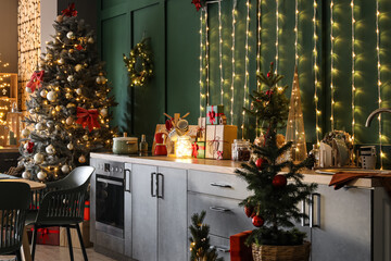 Interior of modern kitchen with glowing lights and Christmas tree
