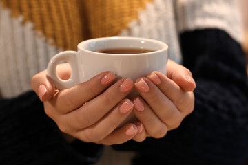 Young woman drinking hot tea, closeup