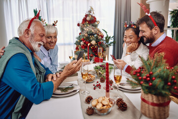 the family sitting at the table shares stories and memories during Christmas dinner