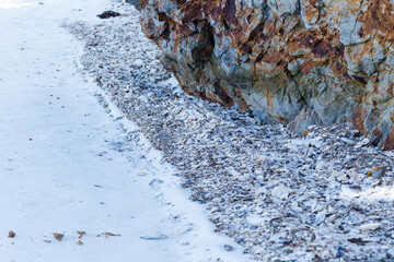 A frozen island with shells thrown onto the ice. Winter island in the sea.
