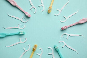 Frame made of toothbrushes and floss toothpicks on color background, closeup