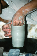 A Woman's Hands Tossing and Forming a Clay Vase on a Pottery Wheel and shaping it with her Fingers