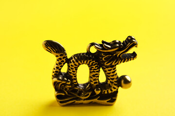 Figurine of Chinese dragon on color background