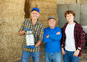 Portrait of farmers of different generations against the background of hay bales. Concept of...