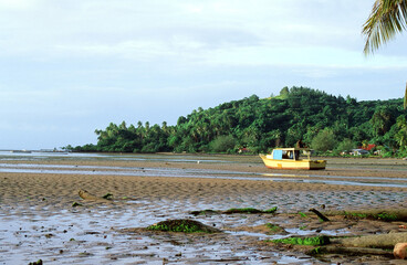 A Low Tide Coral Reef with a Native Fishing Boat waiting for High Tide before Being Able to go...