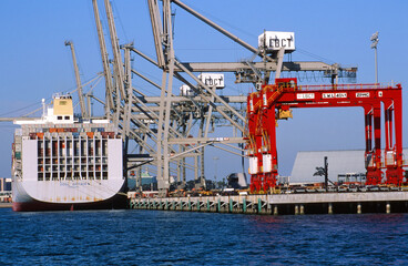 A Container Crane Dock Unloading a Ship with Containers from all over the World as Part of Shipping...