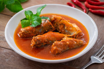 Canned fish in tomato sauce on plate.