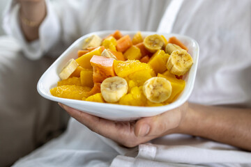 Closeup of person holding bowl of fresh fruit