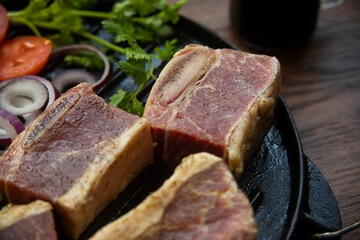 BEEF CUT INTO PIECES, WITH VEGETABLES SUCH AS TOMATO, ONION, PARSLEY, PEPPERS AND POTATOES, ON GRILL, READY TO BRING TO THE FIRE
