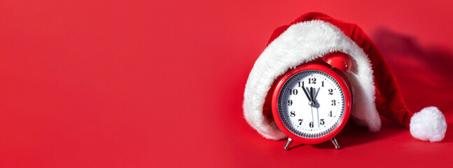 Red clock with Christmas Santa hat. Time for Christmas shopping concept. Blank copy space for text.
