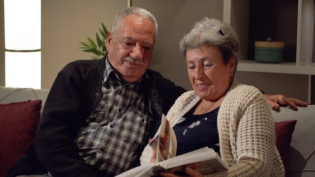 Elderly couple emotional moments. Elderly husband and wife looking at photo album. Being a family, getting old, going back to the past. Happy moments