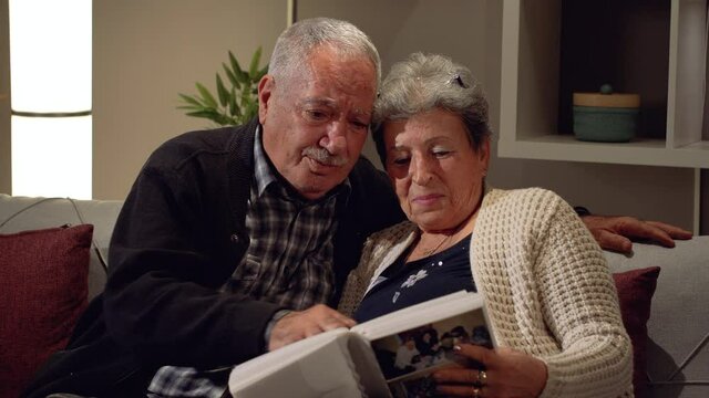 Elderly couple emotional moments. Elderly husband and wife looking at photo album. Being a family, getting old, going back to the past. Happy moments